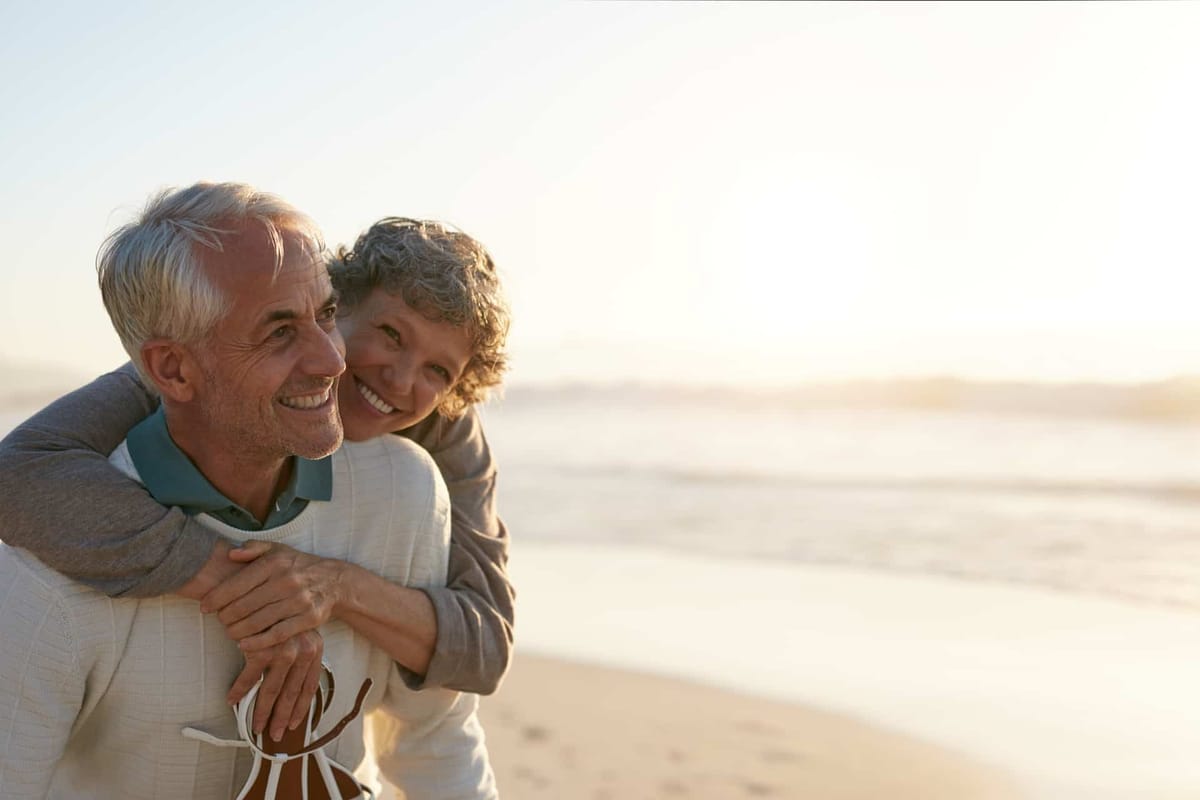 Older adult couple walking together outdoors near the beach